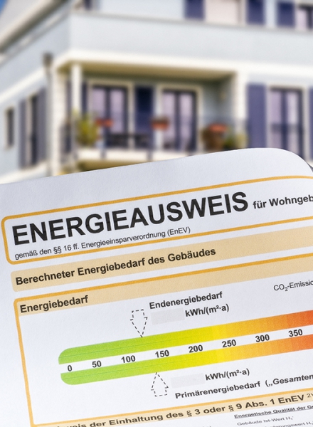 Energieausweis mit Mehrfamilienhäusern im Hintergrund